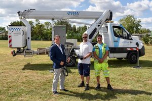 Bürgermeister von Leopoldsdorf, Fritz Blasnek, steht mit zwei Monteuren der eww Anlagentechnik vor einem Hubsteiger