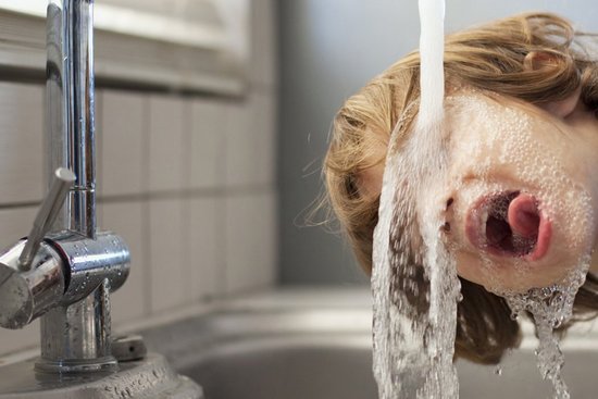 Trinkbrunnen Trinkwasser  Junge trinkt Wasser bei Wasserleitung