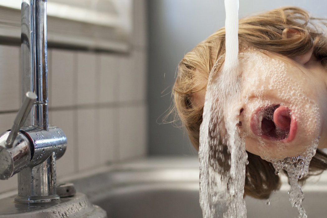 Trinkbrunnen Trinkwasser Junge trinkt Wasser bei Wasserleitung