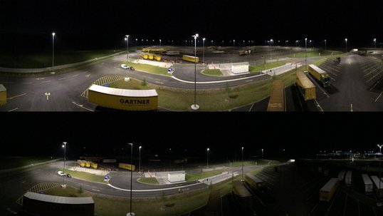 Beleuchteter Parkplatz mit Lastwagen bei Nacht