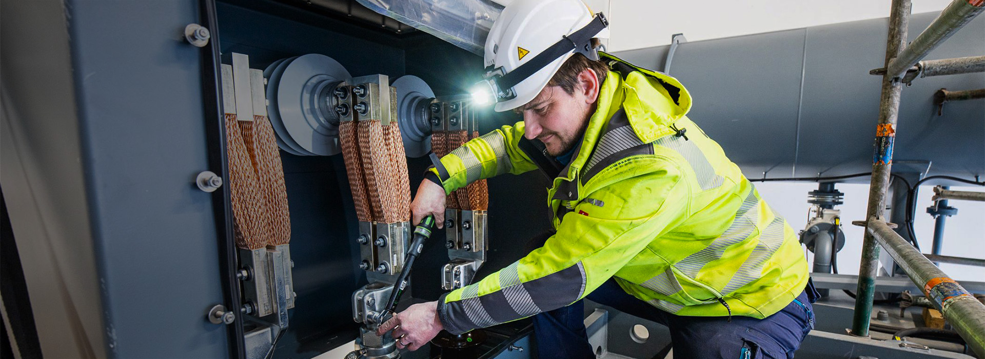 Mann in Arbeitskleidung arbeitet an einer Maschine