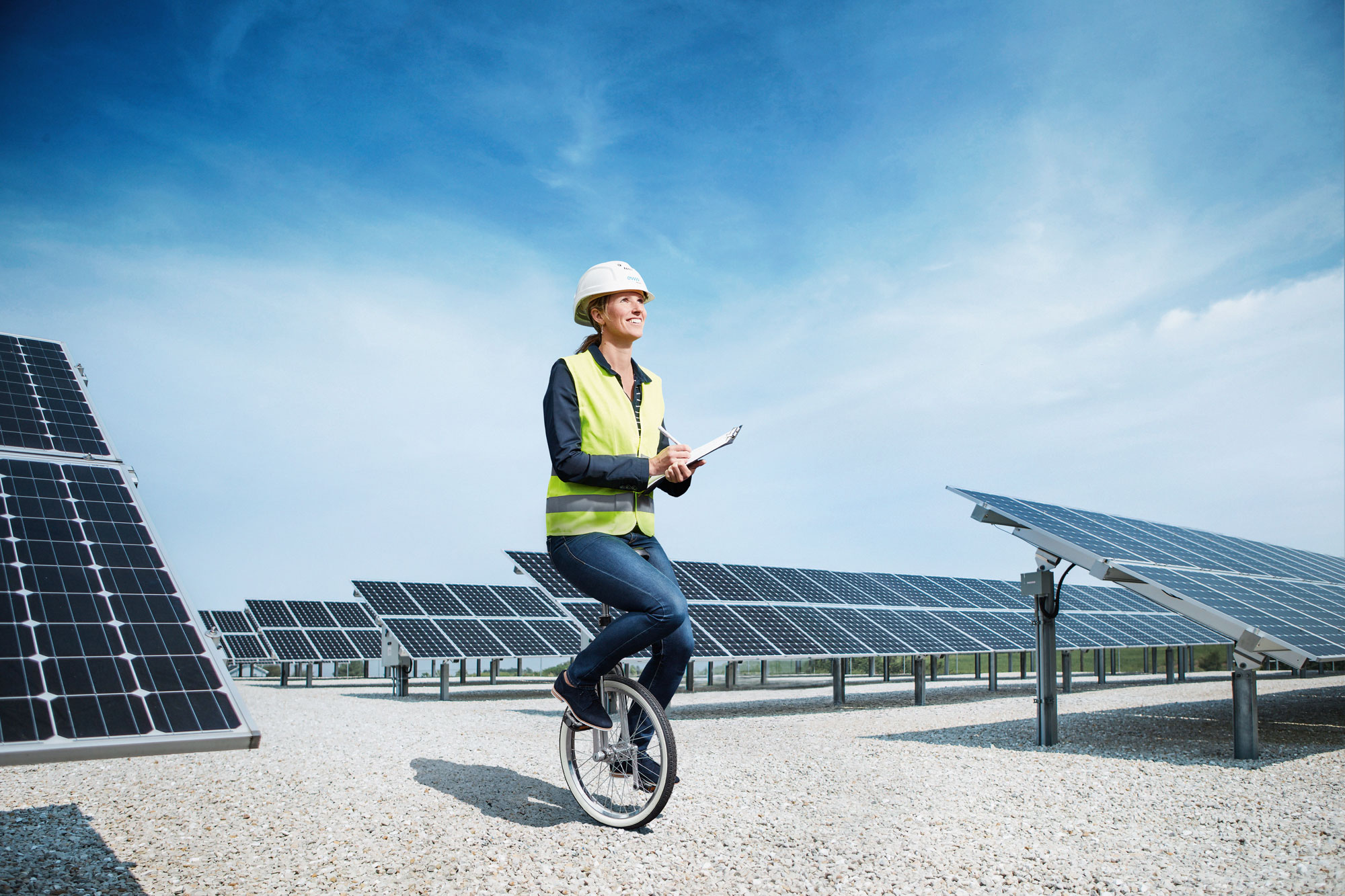Talent braucht Förderer Mitarbeiterin auf Einrad vor Solar Paneelen